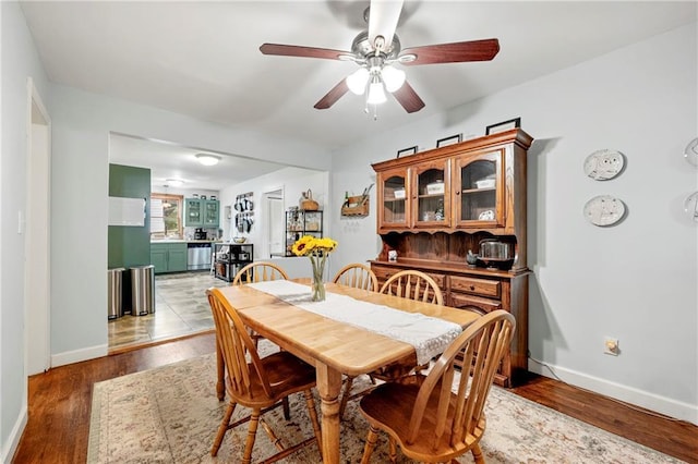 dining room with wood finished floors, baseboards, and a ceiling fan