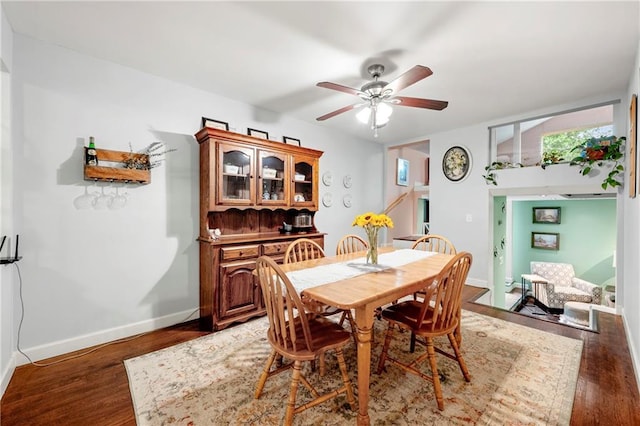 dining space with ceiling fan, baseboards, and light wood-style floors