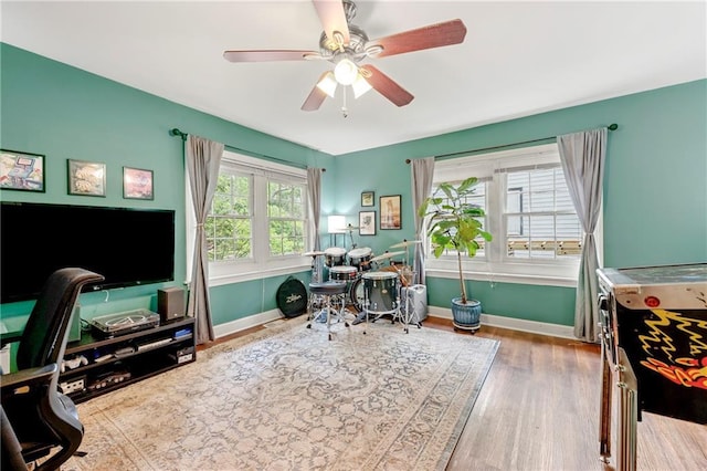game room featuring baseboards, ceiling fan, and wood finished floors