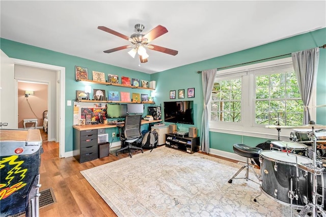 office space with baseboards, ceiling fan, and wood finished floors