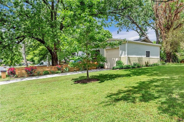 view of yard featuring fence and a garage