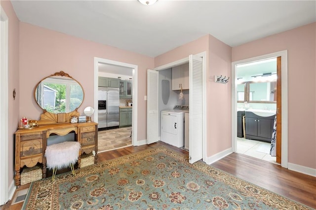 interior space with baseboards, visible vents, a sink, and wood finished floors