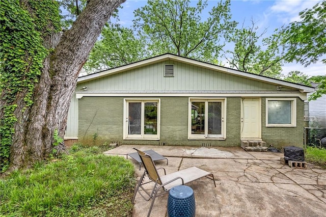rear view of house featuring a patio area, brick siding, and entry steps