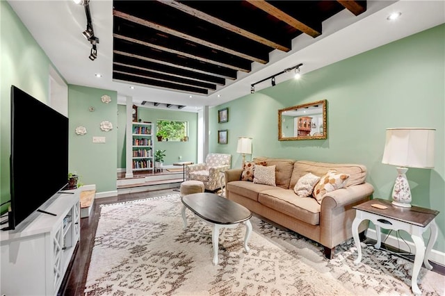living area featuring beam ceiling, wood finished floors, rail lighting, recessed lighting, and baseboards
