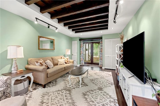 living room featuring beamed ceiling and track lighting