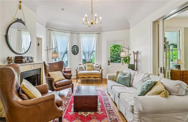 living area featuring a notable chandelier, wood finished floors, and a fireplace