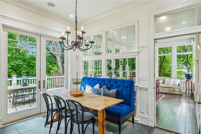 sunroom / solarium featuring a healthy amount of sunlight and a chandelier