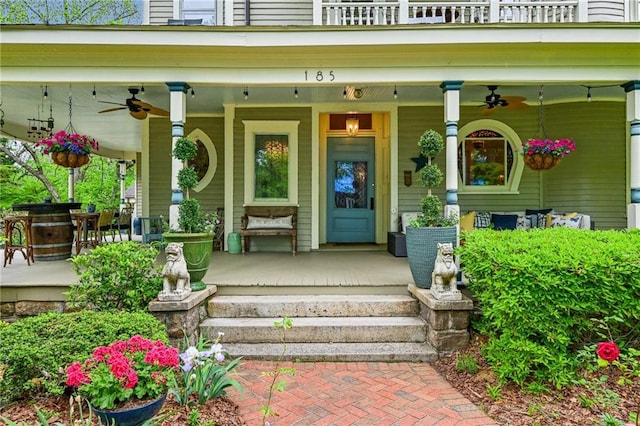view of exterior entry featuring a porch, ceiling fan, and a balcony
