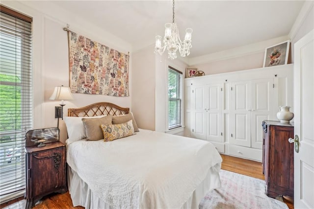 bedroom with wood finished floors and a notable chandelier