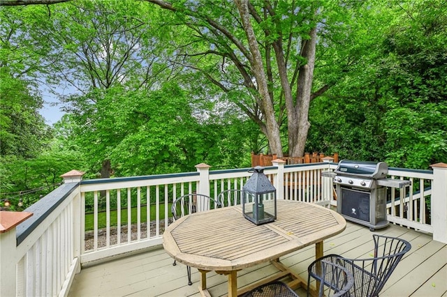 wooden terrace with outdoor dining area and a grill