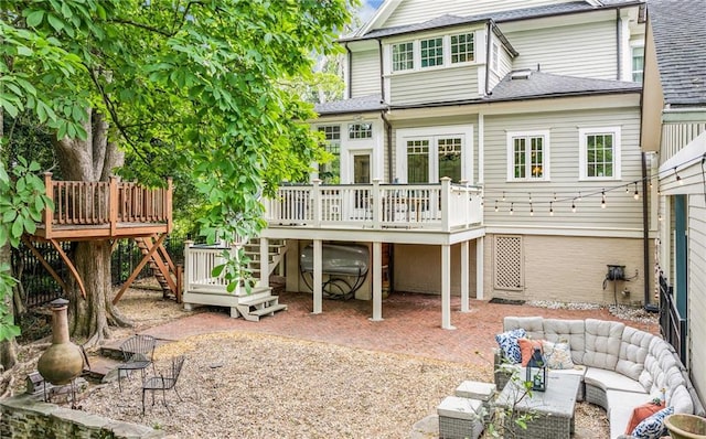 rear view of house with a patio, roof with shingles, a wooden deck, and stairway