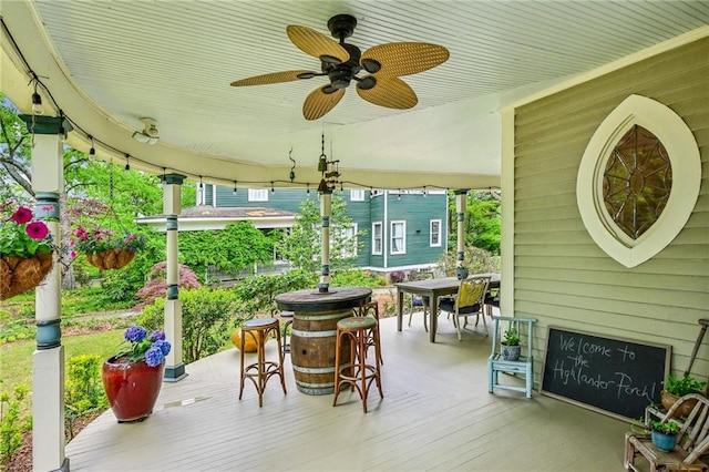 wooden deck with a ceiling fan and outdoor dining space