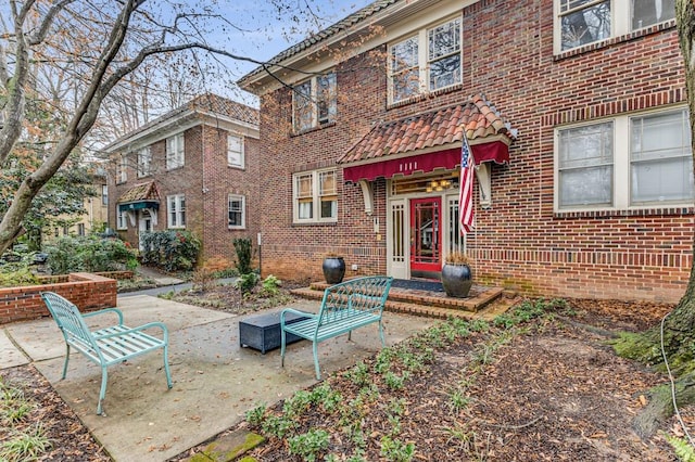 exterior space with a patio area and brick siding