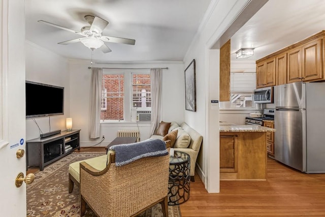 interior space with light wood-style floors, plenty of natural light, crown molding, and ceiling fan