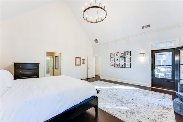 bedroom with dark hardwood / wood-style floors, connected bathroom, high vaulted ceiling, and a chandelier