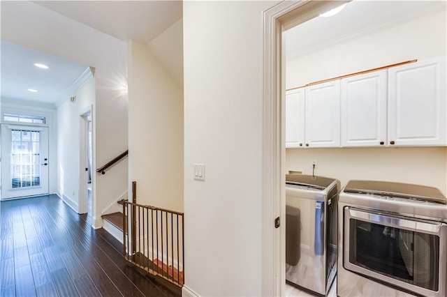 laundry room with cabinets, crown molding, washer and clothes dryer, and dark wood-type flooring