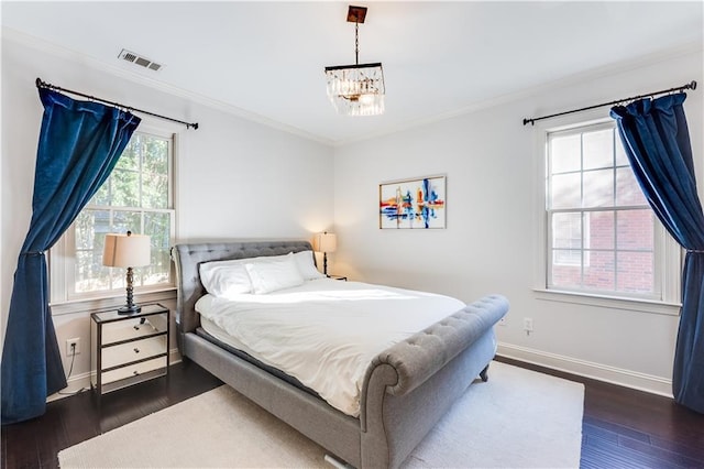 bedroom with crown molding, dark wood-type flooring, and a notable chandelier