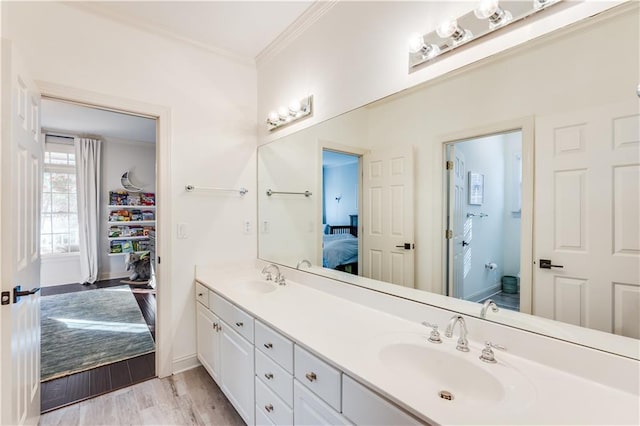 bathroom featuring hardwood / wood-style floors, vanity, and crown molding