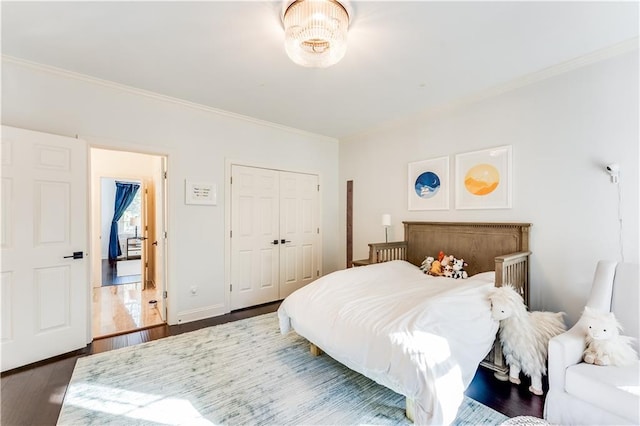 bedroom with dark hardwood / wood-style floors, a closet, and ornamental molding