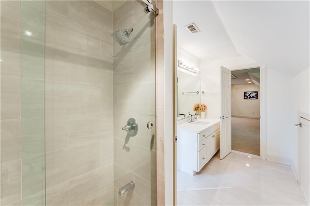 bathroom featuring tiled shower and vanity