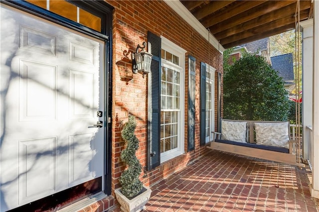 view of exterior entry featuring covered porch