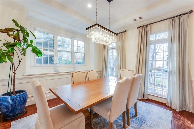 dining space with crown molding, dark hardwood / wood-style floors, and a notable chandelier