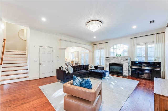 living room with dark hardwood / wood-style floors, ornamental molding, and a fireplace