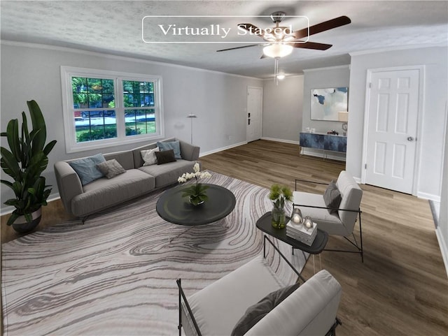 living room with wood-type flooring, crown molding, and ceiling fan