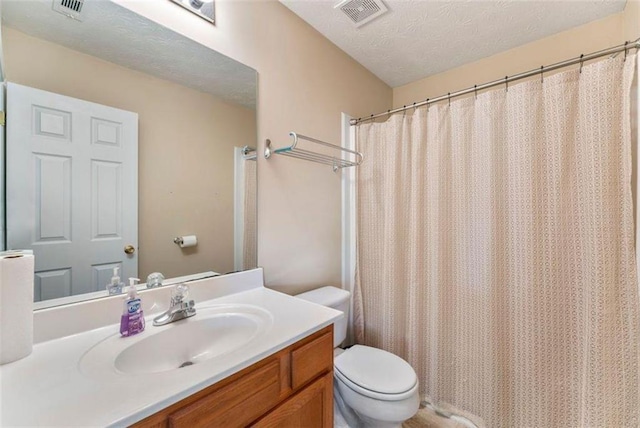 bathroom featuring a shower with curtain, vanity, toilet, and a textured ceiling