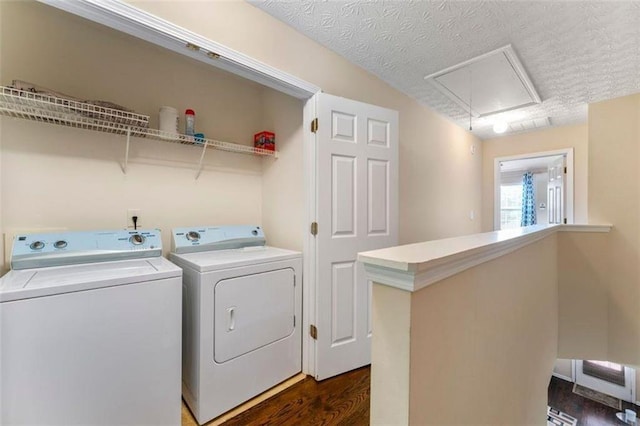 washroom with washing machine and dryer, dark hardwood / wood-style flooring, and a textured ceiling