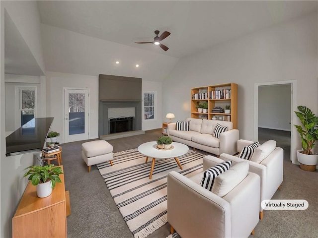 carpeted living room with a fireplace, vaulted ceiling, and a ceiling fan