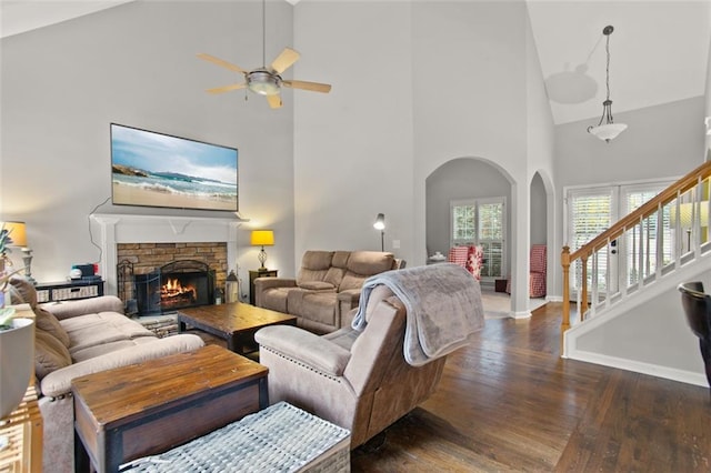 living room featuring high vaulted ceiling, dark hardwood / wood-style flooring, a fireplace, and ceiling fan