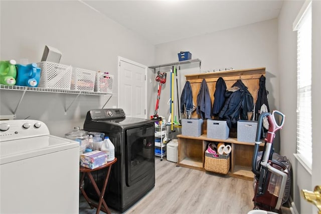 laundry area with light hardwood / wood-style floors and washer and clothes dryer