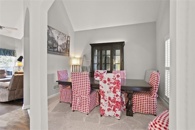 carpeted dining space featuring lofted ceiling, ceiling fan, and plenty of natural light