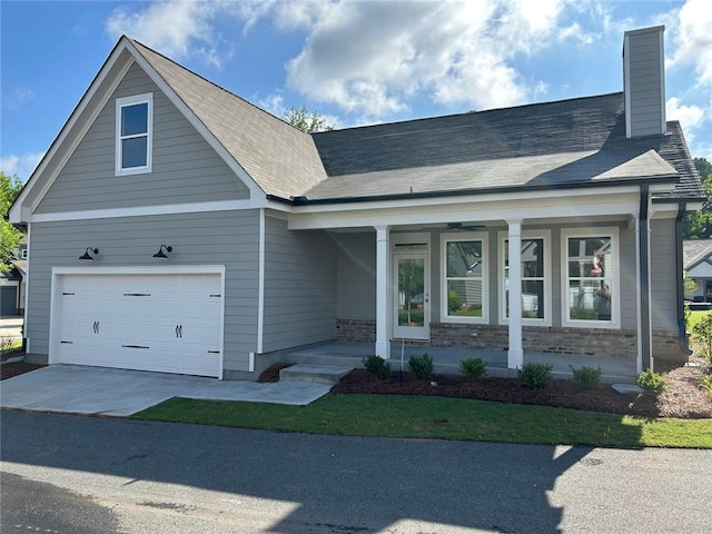 241 Saratoga Dr, Acworth, GA 30102 - view of front facade with covered porch, a chimney, driveway, brick siding, and a garage