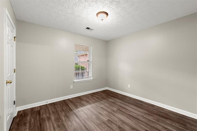 unfurnished room featuring wood-type flooring and a textured ceiling