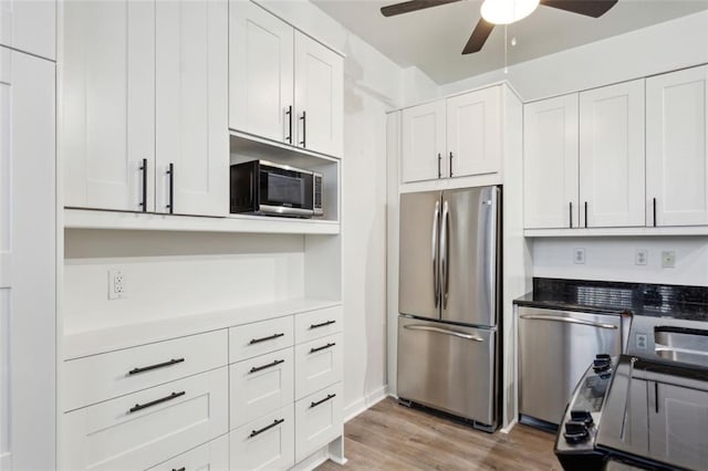 kitchen featuring ceiling fan, appliances with stainless steel finishes, light hardwood / wood-style floors, and white cabinetry