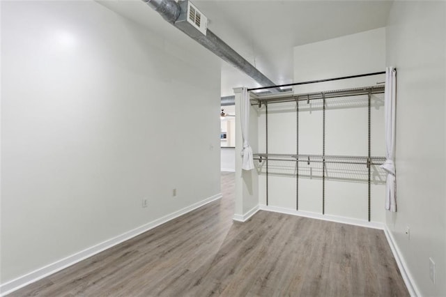 walk in closet with ceiling fan and hardwood / wood-style floors