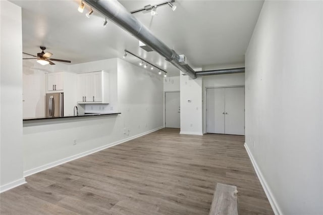 unfurnished living room with ceiling fan and light hardwood / wood-style floors