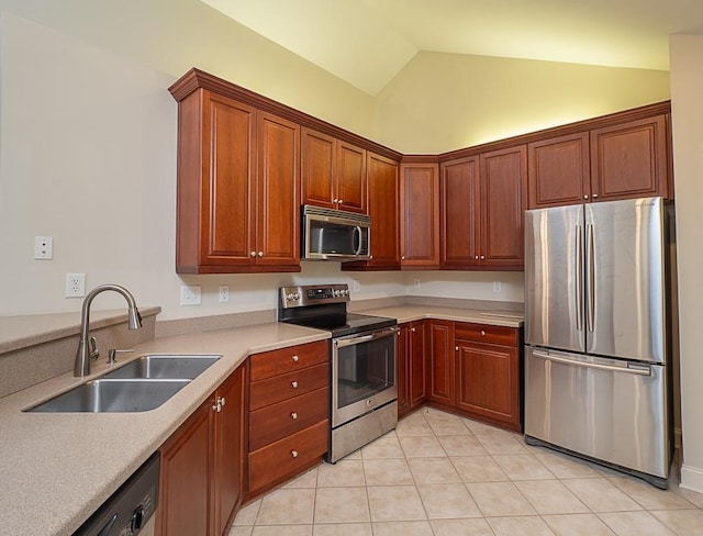 kitchen featuring light tile patterned flooring, sink, appliances with stainless steel finishes, and vaulted ceiling