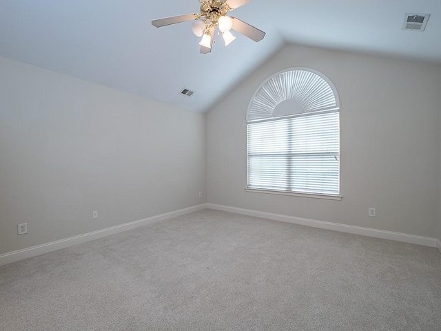 empty room with ceiling fan, light colored carpet, and lofted ceiling