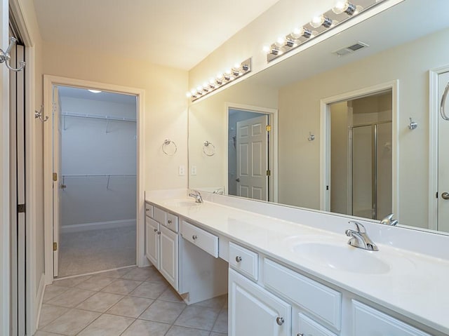 bathroom featuring tile patterned flooring, vanity, and a shower with door