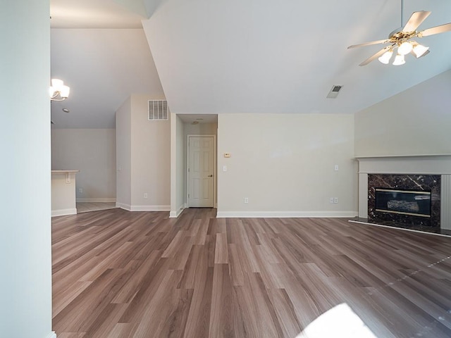 unfurnished living room with a premium fireplace, ceiling fan, and hardwood / wood-style flooring