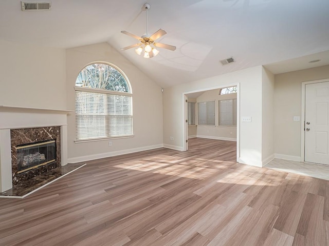 unfurnished living room featuring hardwood / wood-style floors, ceiling fan, a premium fireplace, and vaulted ceiling