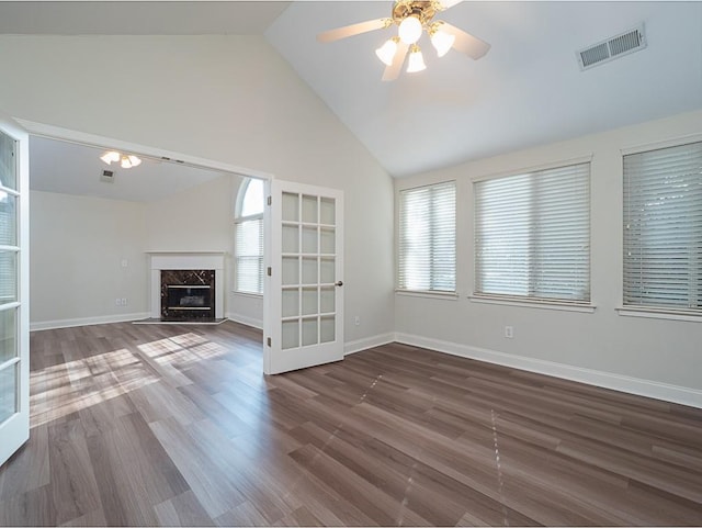 unfurnished living room with french doors, dark hardwood / wood-style flooring, ceiling fan, high vaulted ceiling, and a fireplace