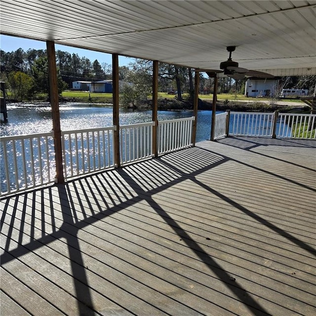 wooden terrace featuring ceiling fan and a water view