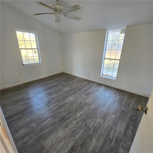 empty room with lofted ceiling, dark wood finished floors, baseboards, and ceiling fan