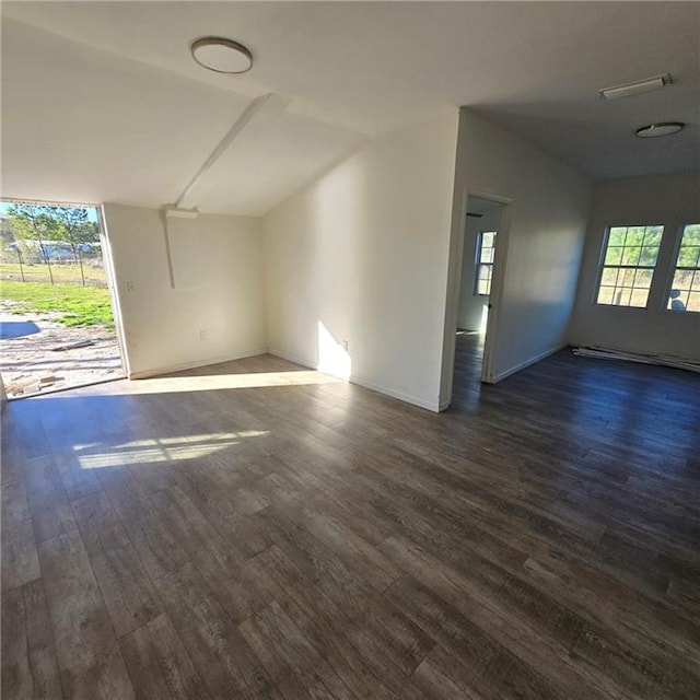 interior space featuring a baseboard heating unit, visible vents, and dark wood finished floors