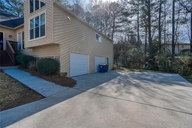 view of property exterior with concrete driveway and an attached garage