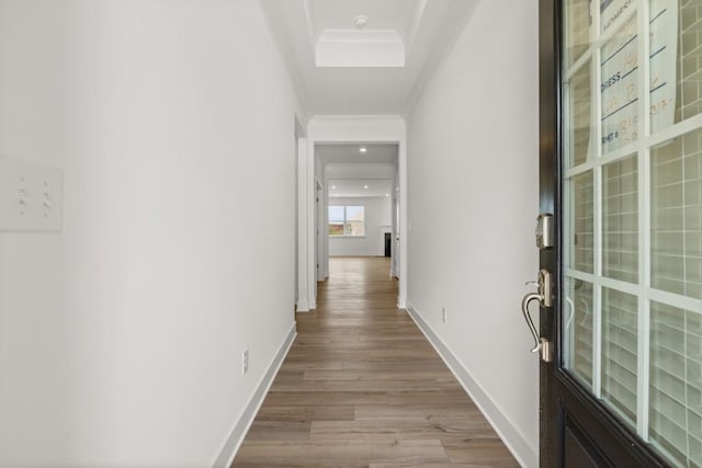 hall with light hardwood / wood-style flooring and ornamental molding